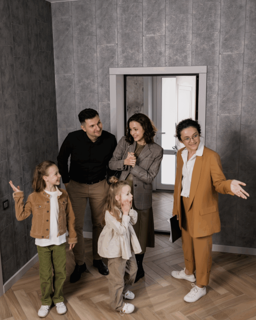 On aperçoit une famille qui vient d'arrivée dans leur nouvelle maison, il y a l'agent immobilière qui les accueil