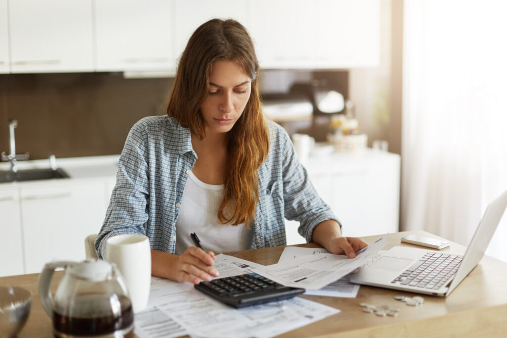 Une jeune femme qui vérifie son budget et fait ses impôts.