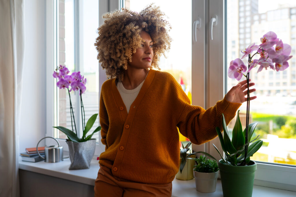 Femme décorant sa maison avec des orchidées